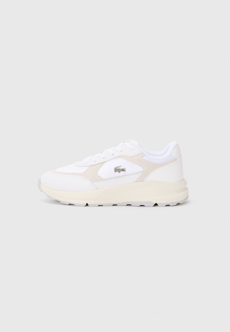 Sneaker atletica bianca con texture liscia, caratterizzata da accenti beige, una sola ammortizzata e un piccolo logo ricamato sul lato.