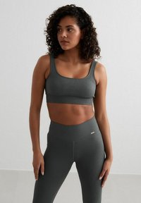 Geribbelde grijze sportbeha en bijpassende high-waisted legging, met een naadloos ontwerp en zachte textuur, geschikt voor sportkleding.