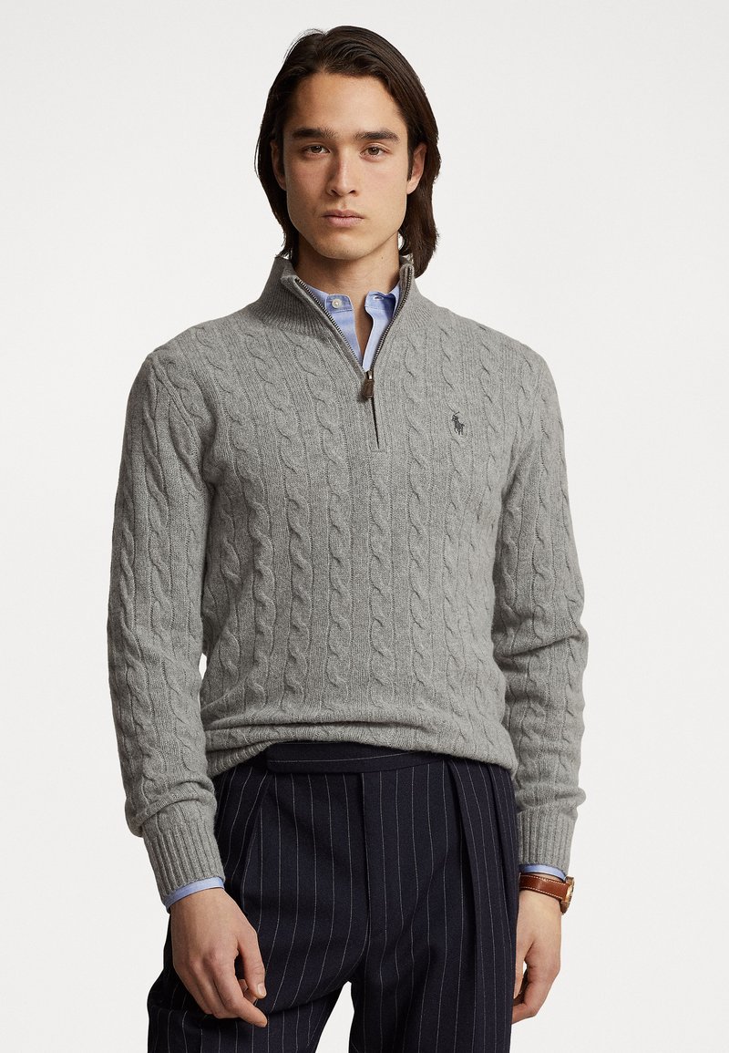 Gray cable-knit sweater with a high collar and half-zip closure. Features ribbed cuffs and a small embroidered logo on the chest.