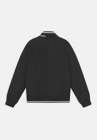 Černá bombardérka s žebrovaným límcem se bílými pruhy a elastickými manžetami. Jednoduchý design, hladká textura a zkrácený střih.