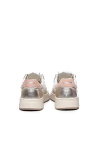 Sneaker bianchi e argento metallizzato con dettagli in suede rosa, dotati di suola spessa e marchio sul tallone. Materiali lisci e testurizzati.