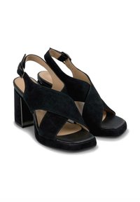 Talons hauts en suède noir à dos nu avec un bout ouvert, dotés de lanières croisées et d'un talon carré. Semelle intérieure en cuir lisse, design minimaliste.