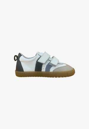 Zapatilla blanca para niños con franjas grises y azul marino, dos tiras de Velcro, puntera beige y suela de goma marrón.