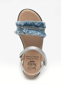 Sandalo scivoloso in denim blu con una cinghia sfilacciata e una cinghia alla caviglia in metallo argentato. Soletta imbottita beige con dettagli del marchio. Suola piatta.