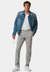 Veste en jean, pantalon texturé gris clair, t-shirt blanc et baskets blanches. Les caractéristiques incluent un devant boutonné, des poches et des lunettes de soleil suspendues.