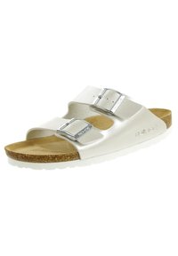 Sandal bianca con due cinghie regolabili, fibbie metalliche, un plantare in sughero e una suola in gomma bianca. Texture liscia con un design minimalista.