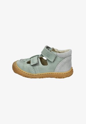 Jasnozielona skórzana sandał z rzepem, perforowaną cholewką i brązową gumową podeszwą. Posiada kontrastujące szare zamszowe akcenty.