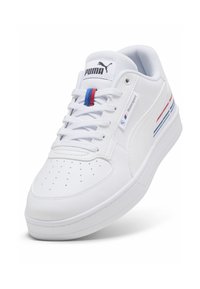 Fehér sneaker sima bőr felsőrésszel, texturált orr résszel, hálós nyelvvel, és színes piros és kék csíkokkal az oldalon. Puma logó látható.
