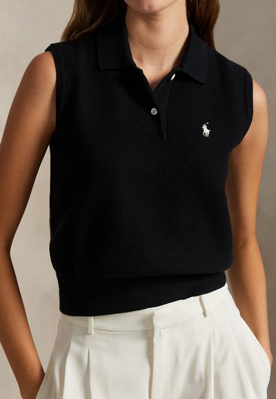 Melns bezroku polo džemperis no teksturēta adīta auduma ar ribotu apmali un nelielu baltu logotipu krūtīs.