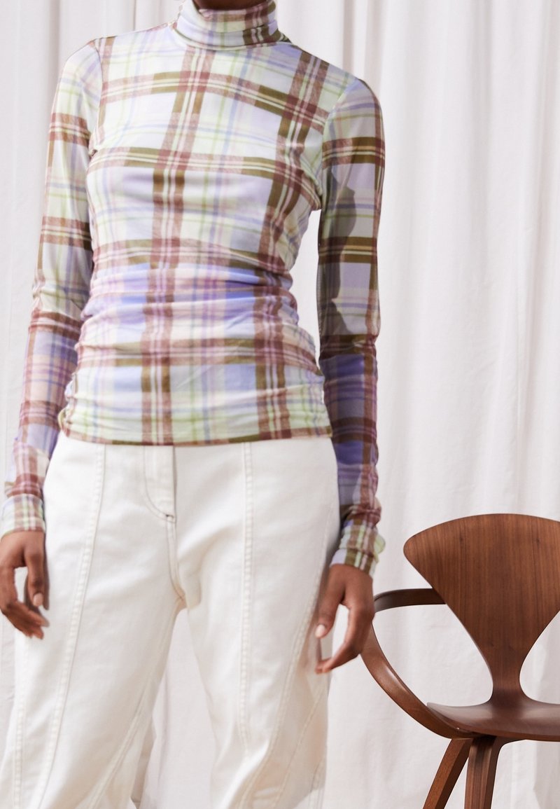 Langærmet turtleneck top i ternet mønster med lilla, grønne og brune nuancer. Tætsiddende design lavet af strækbart, glat stof.