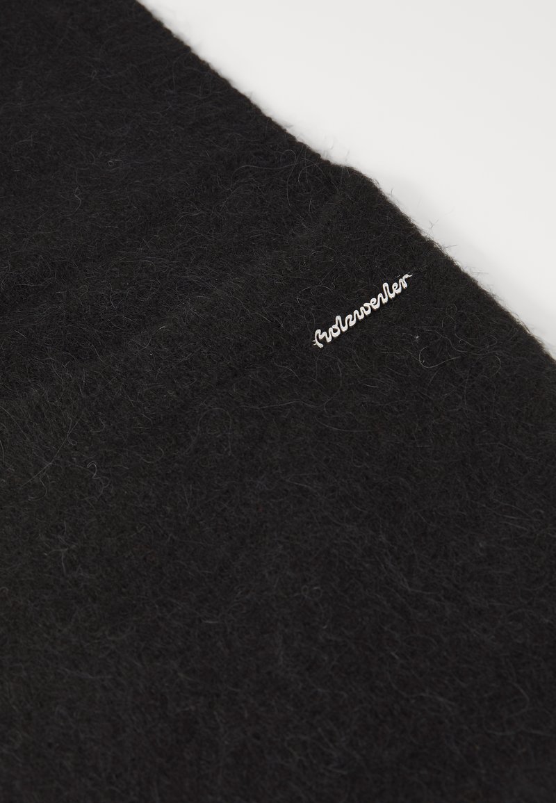 Écharpe en laine noire avec une texture douce et moelleuse. Présente un logo brodé argenté sur un côté. Design simple et rectangulaire.