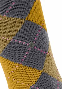 Calza colorata lavorata a maglia con un motivo a rombi in grigio, giallo e beige, con cuciture rosa e un piccolo etichetta metallica di marca.