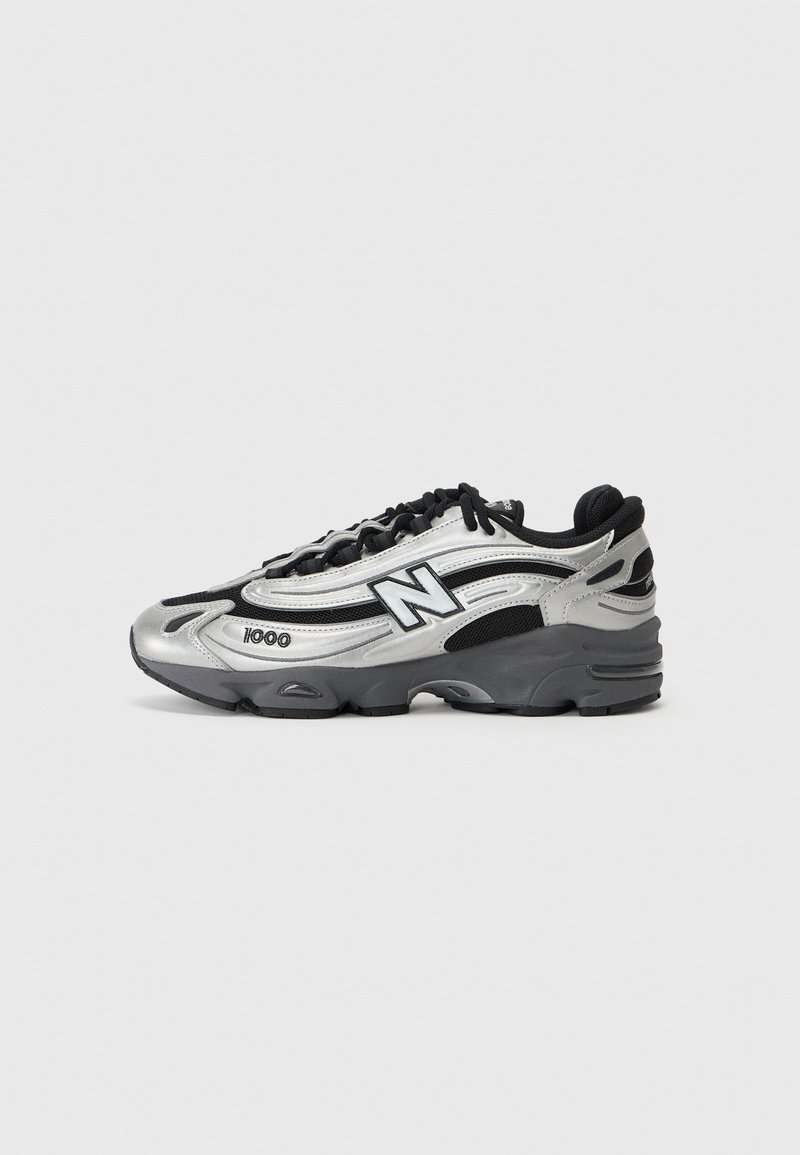 Silver and black athletic shoes featuring a mesh upper, cushioned sole, lace-up design, and side branding detail.