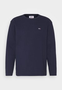 Námořnická dlouhá tričko s kulatým výstřihem vyrobené z měkké bavlněné tkaniny, s malou nášivkou na hrudi a žebrovanými manžetami a výstřihem.