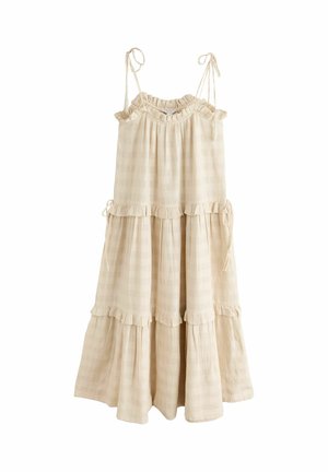 Beige sleeveless tiered dress with ruffle details, tied shoulder straps, and subtle checkered texture, hanging against white background.