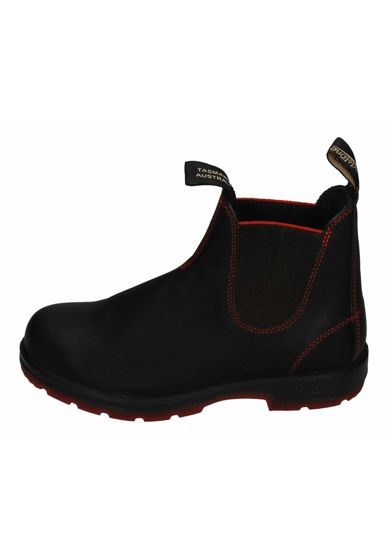 Black ankle boot with elastic side, red stitching, and durable material. Features a textured fabric panel and a rubber sole with red accents.