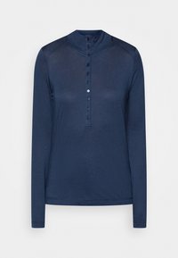 Mörkblå långärmad skjorta med hög krage och en vertikal rad av nio knappar, där en av dessa är vit, mitt fram.