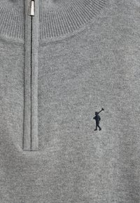 Maglione grigio con zip realizzato in morbido tessuto a maglia. Presenta un colletto alto e un piccolo logo ricamato blu scuro sulla parte sinistra del petto.