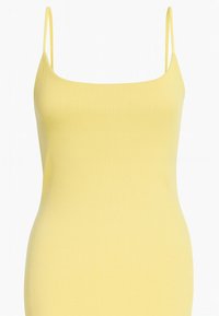 Żółta dzianinowa sukienka na ramiączkach z cienkimi paskami i dopasowanym krojem. Gładka faktura i długość do połowy uda sprawiają, że jest odpowiednia na różne okazje.