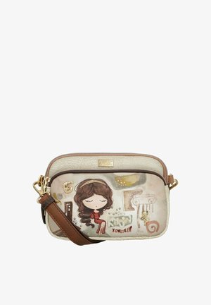 Bolso beige bandolera con correa marrón, que presenta una ilustración de una niña con vestido rojo, formas abstractas y la palabra "YOURSELF" en el bolsillo delantero.