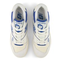 White and blue New Balance 550 sneakers with mesh and suede materials, featuring a logo on the tongue, laces, and a subtle perforated pattern.