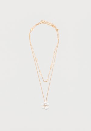 Collier délicat à double chaîne en or avec de petites formes en diamant et un pendentif en forme de fleur blanche à cinq pétales avec un centre en strass.