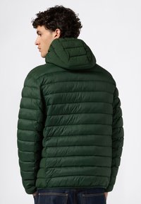 Ciemnozielona kurtka puchowa z kapturem, posiadająca pikowaną fakturę, teksturowany materiał oraz prążkowane szwy na ramionach i plecach.