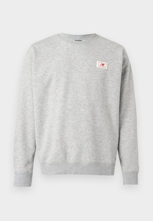 Γκρι φούτερ από μαλακό ύφασμα, με στρογγυλή λαιμόκοψη, ριμπ μανσέτες και ένα μικρό λογότυπο στο μπροστινό μέρος.