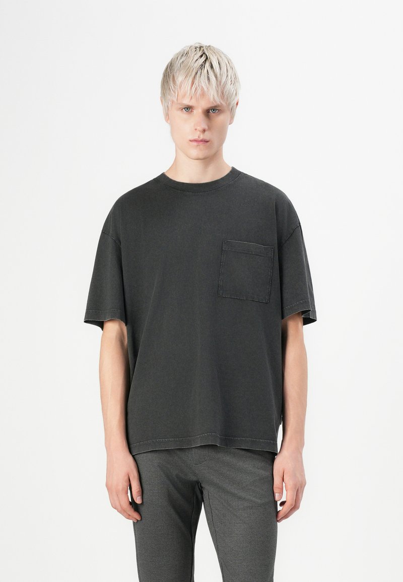 Dark gray short-sleeve t-shirt with a round neckline and front patch pocket. Made of soft cotton fabric, featuring a relaxed fit and simple design.