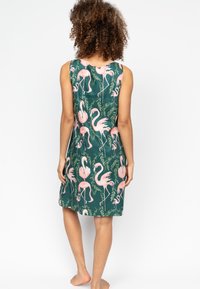Sukienka bez rękawów w zielonym kolorze z wzorem flamingów i roślinności. Lekka tkanina, długość do kolan, luźny krój.