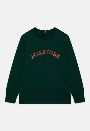 Donkergroen shirt met lange mouwen en ronde hals, met "HILFIGER" in grote, gebogen rode en witte letters geborduurd over de borst.