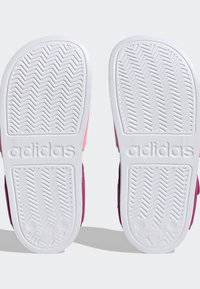 Adidas sandále s hornej časťou z ružového a fialového textilu, bielymi gumovými podrážkami s rybími kosťami a embosovanou značkou. Veľkosť označená ako 12.