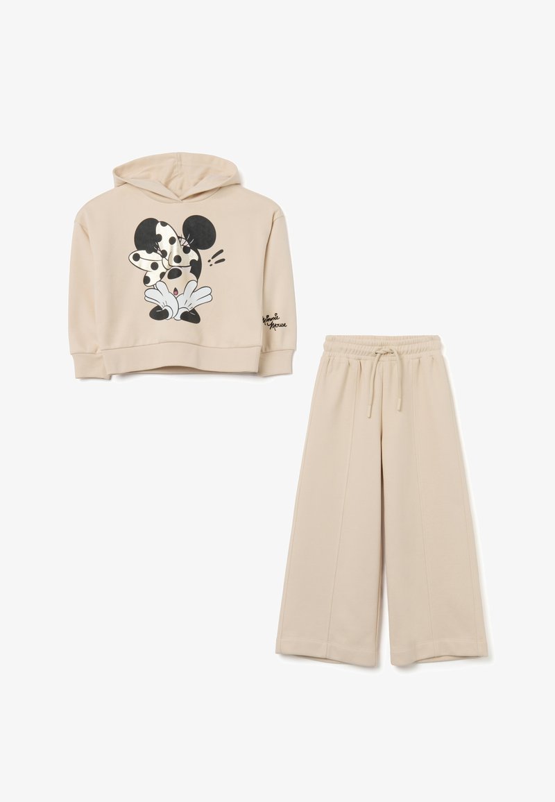 Beige hoodie met een zwart-wit Minnie Mouse graphic; gecombineerd met bijpassende brede broek. Zachte stof textuur.