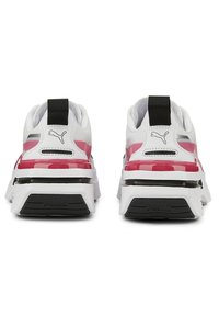 Baskets Puma avec une tige blanche, des accents roses, un talon noir et une semelle extérieure texturée. Elles présentent un col rembourré et un logo de la marque.