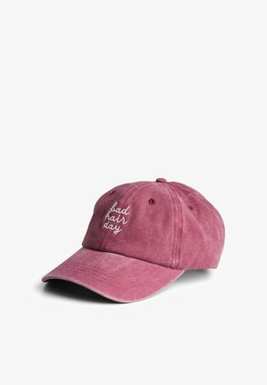 Støvet lyserød baseballkasket med buet skygge og hvid broderet tekst "bad hair day" foran, mod en hvid baggrund.