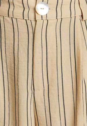 Beidzs strīpains audums ar šaurām melnām līnijām, ar lielu baltu pogu un kroku dizainu. Mīksta tekstūra un kārtīgs apdare.