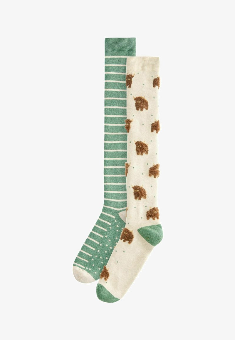Kniestrümpfe; einer ist grün mit weißen Streifen, der andere cremefarben mit braunen Tiermotiven und grünen Akzenten. Weicher Stoff, verspielte Muster.