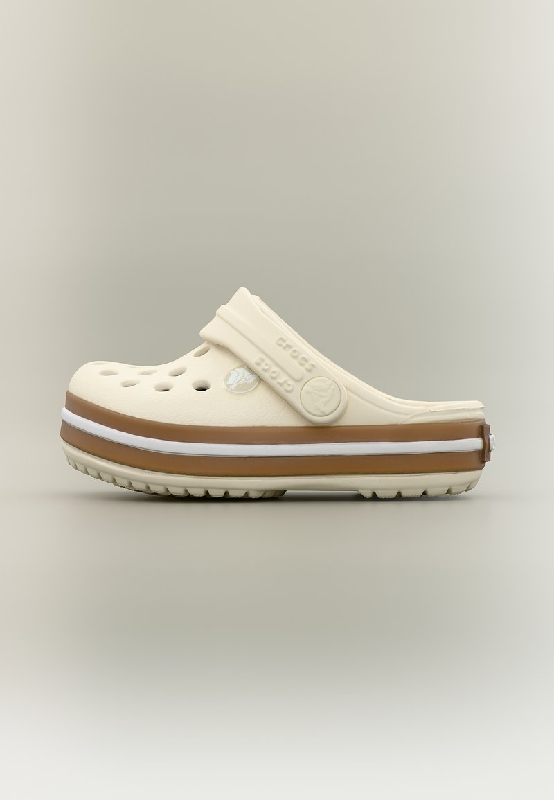 Μπεζ και καφέ παπούτσι Crocs με οπές αερισμού και ρυθμιζόμενο λουράκι στη φτέρνα σε ουδέτερο φόντο, πλευρική όψη.