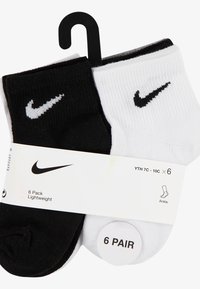 Zestaw sześciu skarpetek do kostki w kolorach czarnym i białym. Mieszanka bawełny, prążkowana faktura, z logo Nike w kontrastujących kolorach na każdej skarpetce.