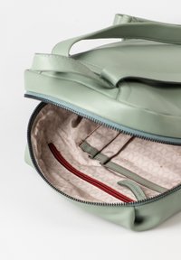 Grüne Lederhandtasche mit doppelten Griffen, Reißverschluss und gemustertem Innenfutter; verfügt über Organizer-Fächer und ein rotes Reißverschlussfach.