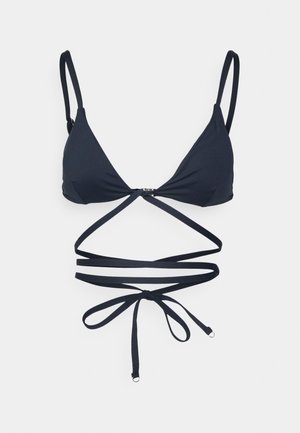 Top de bikini triangular azul marinho com tiras finas ajustáveis e um design em cruz. Apresenta um fecho metálico no centro e textura de tecido suave.
