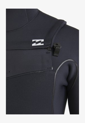 Close-up of black wetsuit with textured chest panel, zipper pull tab, and white wave logo on the upper chest area.