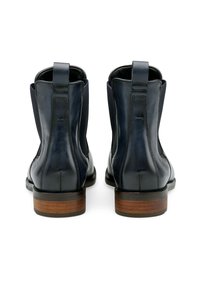 Bottines en cuir noir avec des panneaux élastiques sur les côtés, des talons en bois et des languettes de tirage. Texture lisse et design épuré.