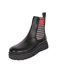 Stivaletto in pelle nera con pannello a houndstooth testurizzato e dettaglio a forma di cuore rosso, dotato di suola spessa e inserti elasticizzati ai lati.
