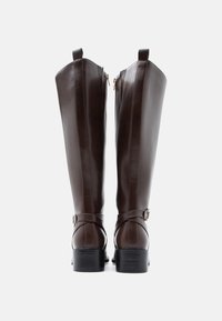 Rudos dirbtinės odos aukšti auliniai batai su lygiu paviršiumi, smailiomis pakulnėmis, šoninėmis užtrauktukais ir kulkšnies dirželiu su auksine sagtimi.