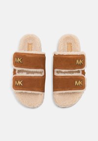 Zapatillas de ante marrón y forro de piel de oveja crema con dos correas ajustables y logotipos dorados de MK, suela plana y diseño de punta abierta.