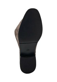 Zapato de cuero marrón con una suela de goma negra texturizada. La suela presenta un diseño con patrón para ofrecer agarre y estabilidad.