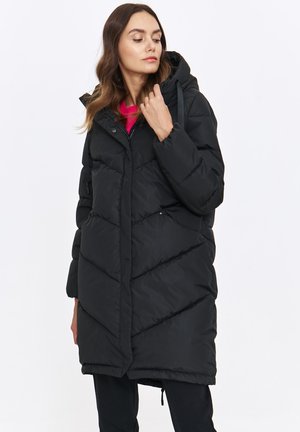 Czarna kurtka puchowa z kapturem, z charakterystycznym wzorem w zygzak, klapą i sznurkami do regulacji. Teksturowany materiał z zamkiem błyskawicznym i zatrzaskami.