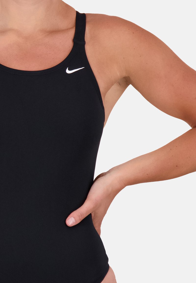 Maillot de bain de sport noir avec un dos nageur, fabriqué dans un matériau lisse, présentant un petit logo Nike blanc sur la poitrine.