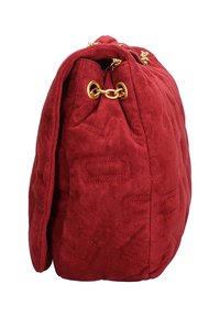 Sac en daim rouge avec texture matelassée et quincaillerie dorée, présentant une ouverture resserrée et une forme arrondie pour un volume supplémentaire.